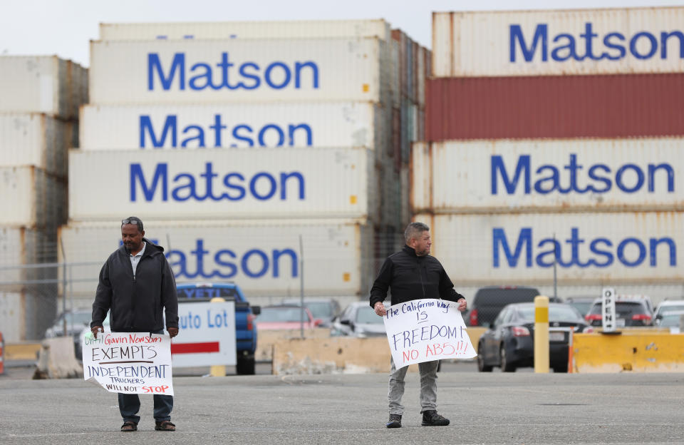 LKW-Fahrer halten Schilder, während sie am 21. Juli 2022 in Oakland, Kalifornien, den Eingang zum Matson-Terminal im Hafen von Oakland blockieren. (Foto von Justin Sullivan/Getty Images)