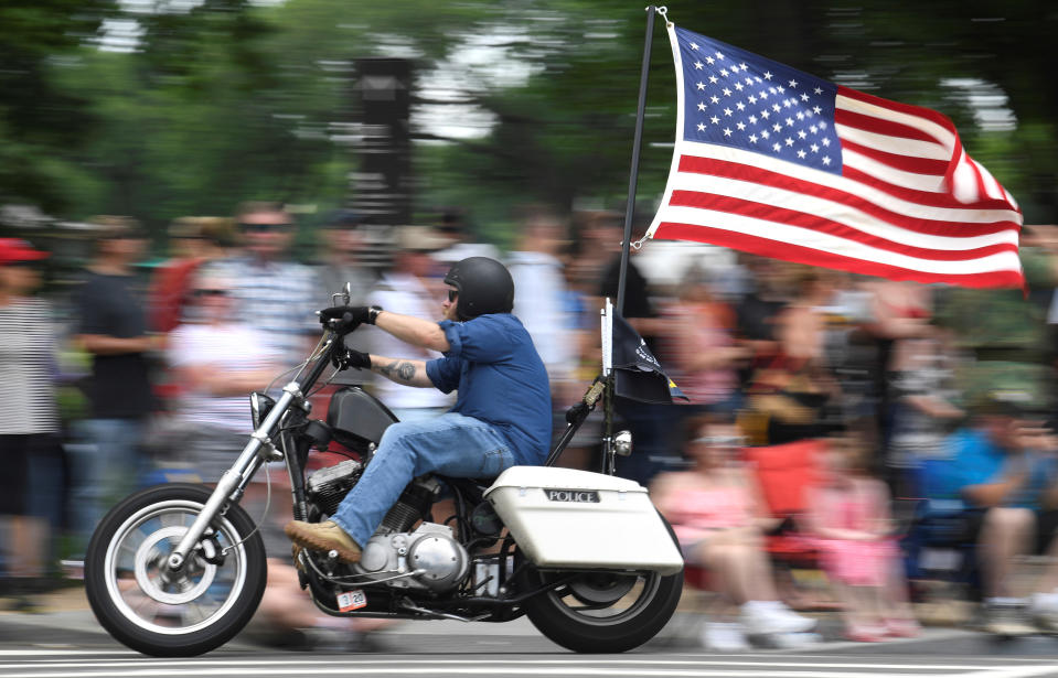 Ein Motorradfahrer mit flatternder amerikanischer Flagge geht während des 32. jährlichen Rolling Thunder an Menschenmassen vorbei