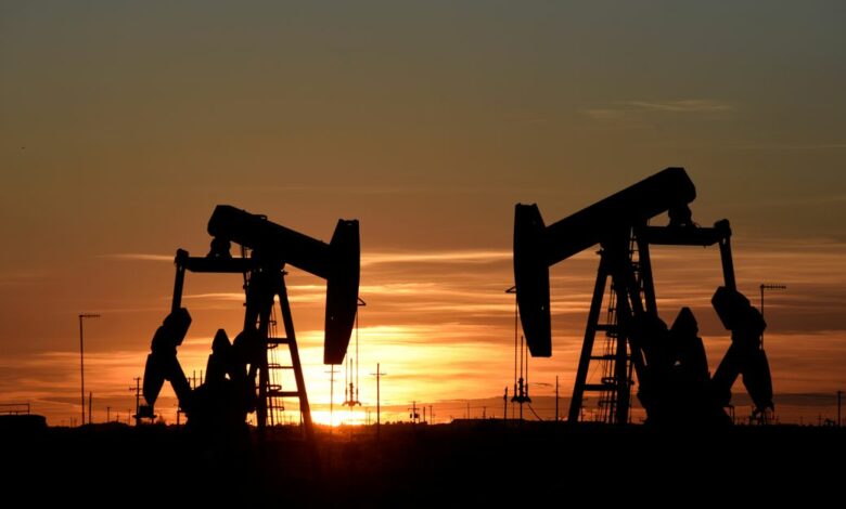 Pump jacks operate at sunset in an oil field in Midland