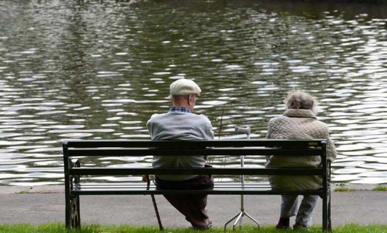 Pensioners sit on a bench in a park, Merthyr Tydfil