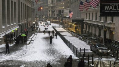Commuters walk through the Financial District during a snow storm in Lower Manhattan