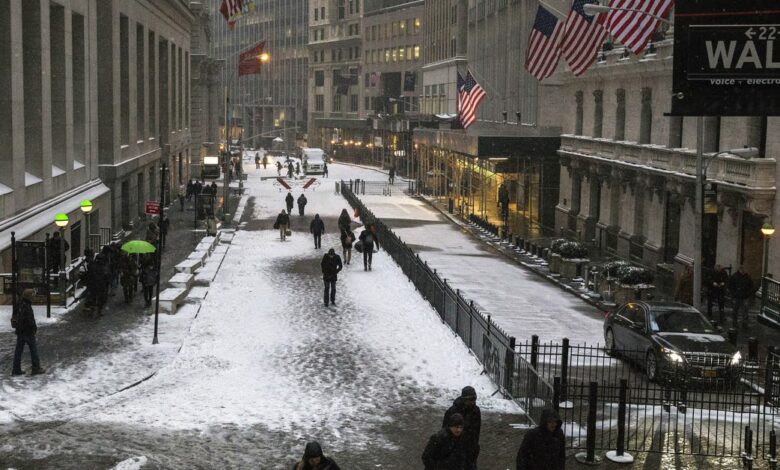 Commuters walk through the Financial District during a snow storm in Lower Manhattan