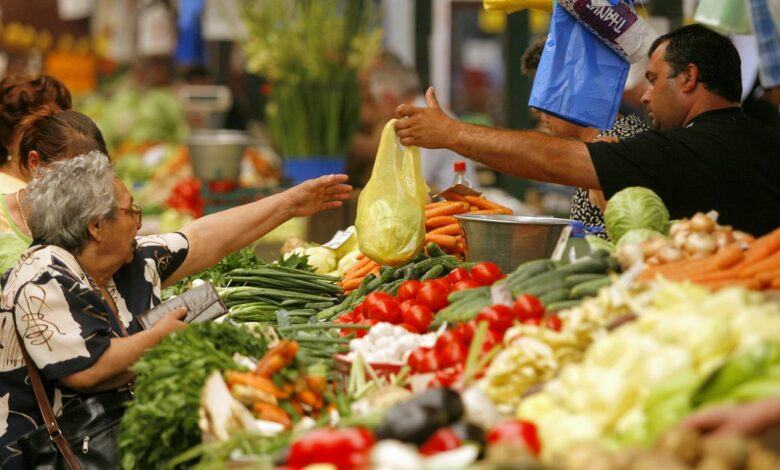 People buy vegetables in a market in Bucharest