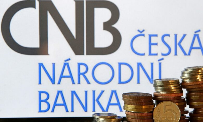 Czech Crown coins are seen in front of a displayed logo of Czech central bank (CNB) in this picture illustration