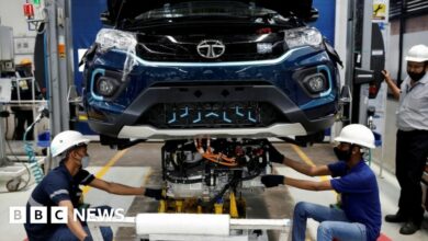 Workers install the electric motor inside a Tata Nexon electric sport utility vehicle (SUV) at the Tata Motors plant in Pune, India.