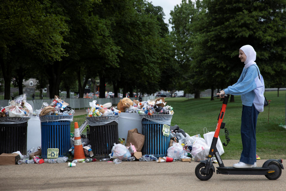 Ein Besucher fährt am überquellenden Müll der Feuerwerksfeier zum Unabhängigkeitstag am Vorabend auf der National Mall in Washington, USA, am 5. Juli 2022 vorbei. REUTERS/Tom Brenner