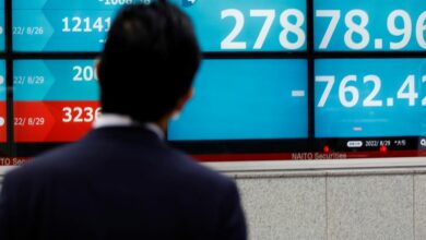 A man looks at an electronic board displaying Japan