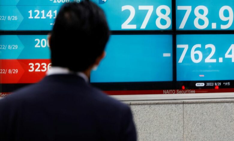A man looks at an electronic board displaying Japan