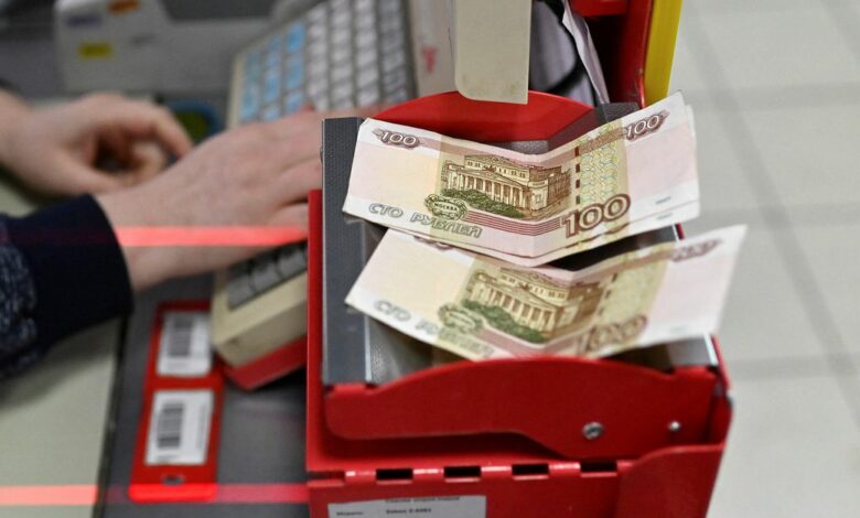 Russian 100-rouble banknotes are placed on a cashier