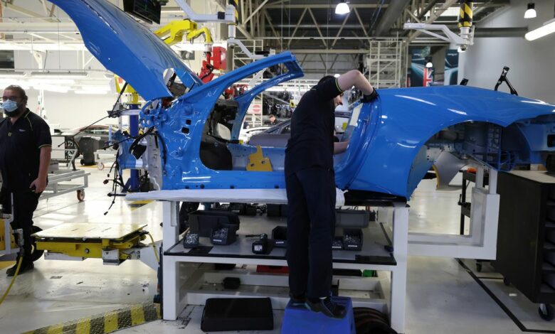 An employee works on an Aston Martin DBS at the company’s factory in Gaydon