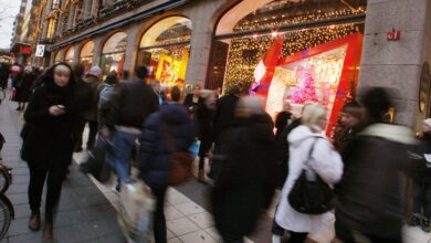 People walk past Christmas window displays at a department store in downtown Stockholm
