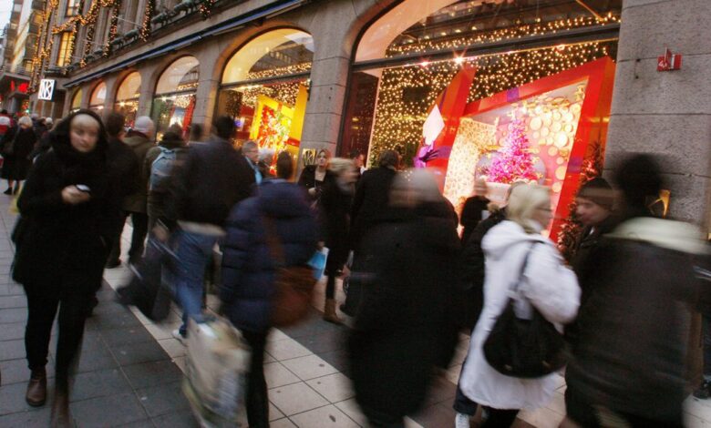 People walk past Christmas window displays at a department store in downtown Stockholm