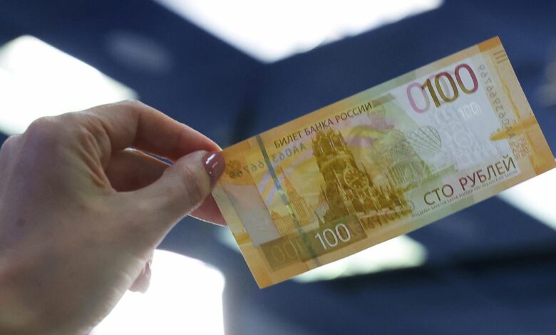 A person holds the newly designed Russian 100-rouble banknote during a presentation in Moscow