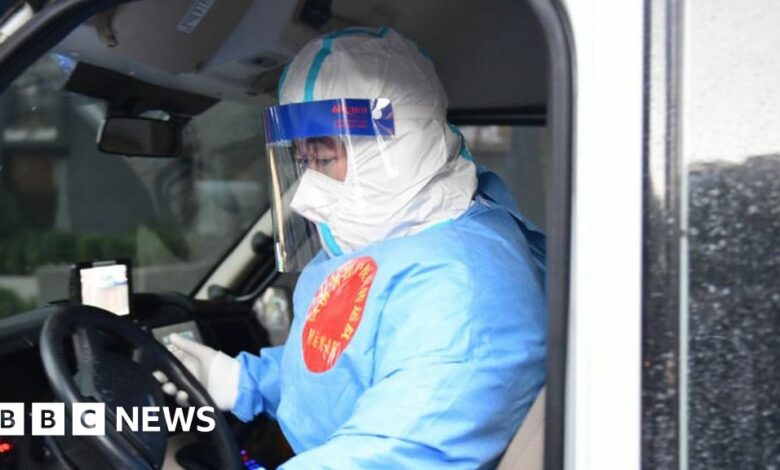 A member of a medical assistance team gets into an ambulance vehicle to transfer Covid-19 patients to a hospital in Shanghai, China.