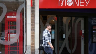 People walk past a Virgin Money store in central London