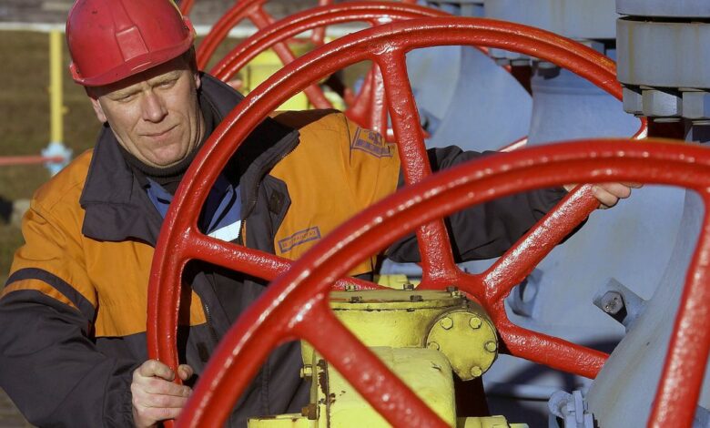 A worker turns a valve at a gas compressor station at Yamal-Europe pipeline near Nesvizh