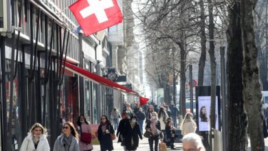 Shoppers walk along the street after the Swiss government relaxed some of its COVID-19 restrictions in Zurich