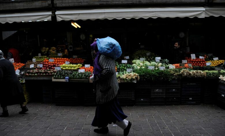 A woman walks past a vegetable market in central Athens