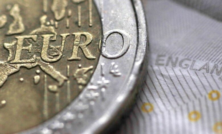 A two Euro coin is pictured next to an English ten Pound note in an illustration