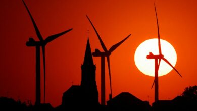 Power-generating windmill turbines and the church of the village are pictured during sunset at a wind park in Bethencourt