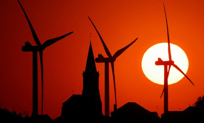 Power-generating windmill turbines and the church of the village are pictured during sunset at a wind park in Bethencourt