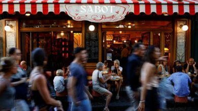 Tourists walk past a restaurant at the Butte Montmartre in Paris