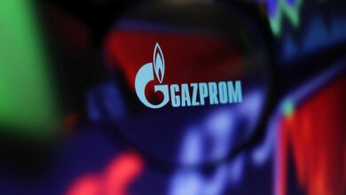 Illustration shows Gazprom logo and stock graph