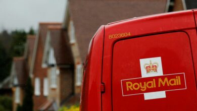 A Royal Mail postal van is parked outside homes in Maybury near Woking in southern England
