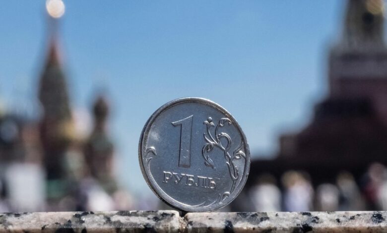 A Russian one rouble coin is pictured in front of a Kremlin tower in Moscow