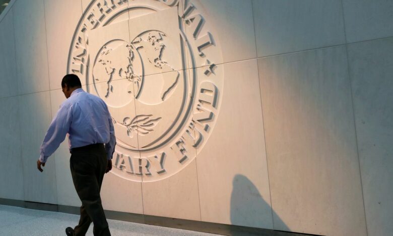 Man walks past the IMF logo at HQ in Washington