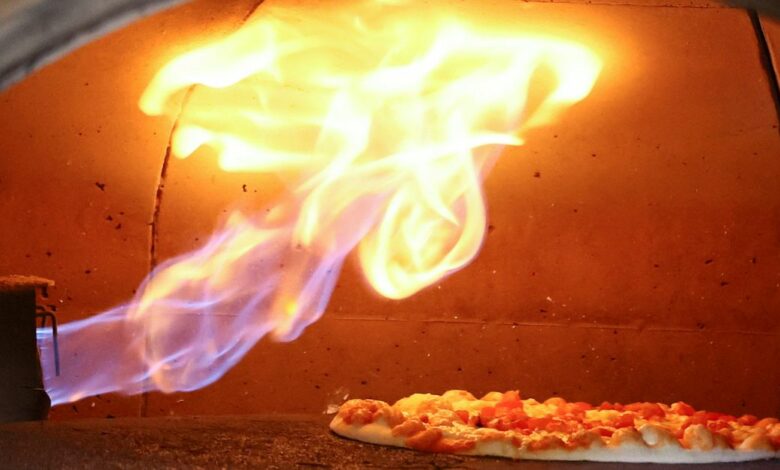 Pizza is baked in a traditional Italian pizza oven fired with natural gas, at a restaurant in Bonn