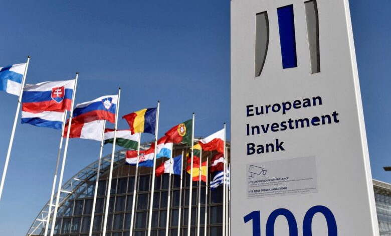 Flags are seen behind the logo of the EIB pictured in the city of Luxembourg